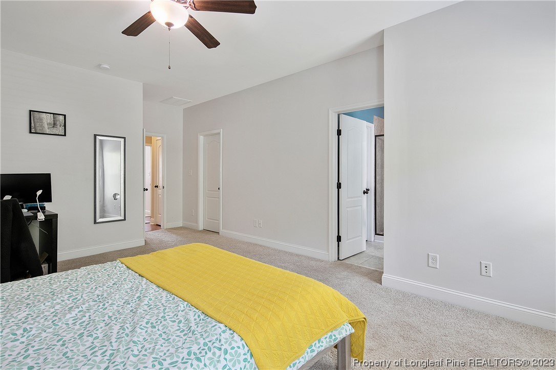 164 Valley Stream Road Spring Lake, NC 28390 - Photo 24 of 49 a spacious bedroom with a bed and a chandelier