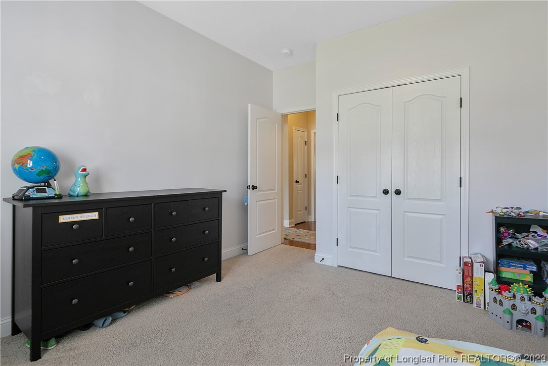 164 Valley Stream Road Spring Lake, NC 28390 - Photo 32 of 49 a room with a baby crib and dresser