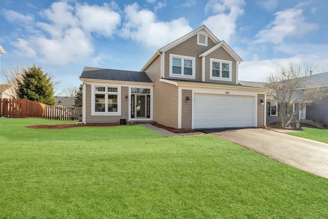 a front view of a house with a garden and yard