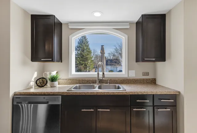 a sink with a granite countertop window and a sink