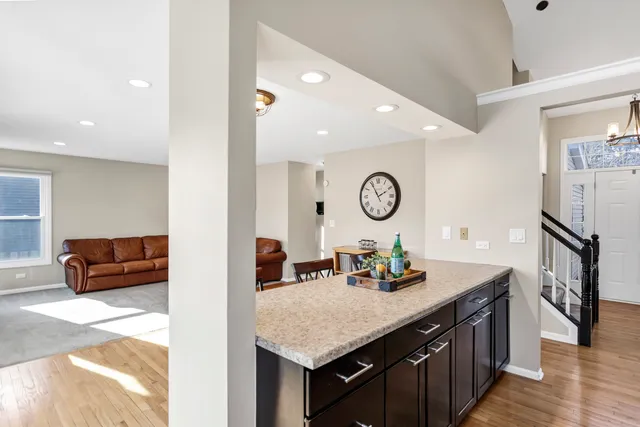 a living room with granite countertop a couch and a clock on a dresser
