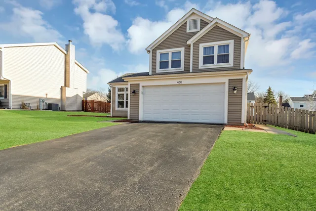 a front view of house with yard and garage