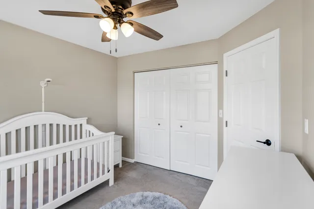 a bedroom with windows and a chandelier fan