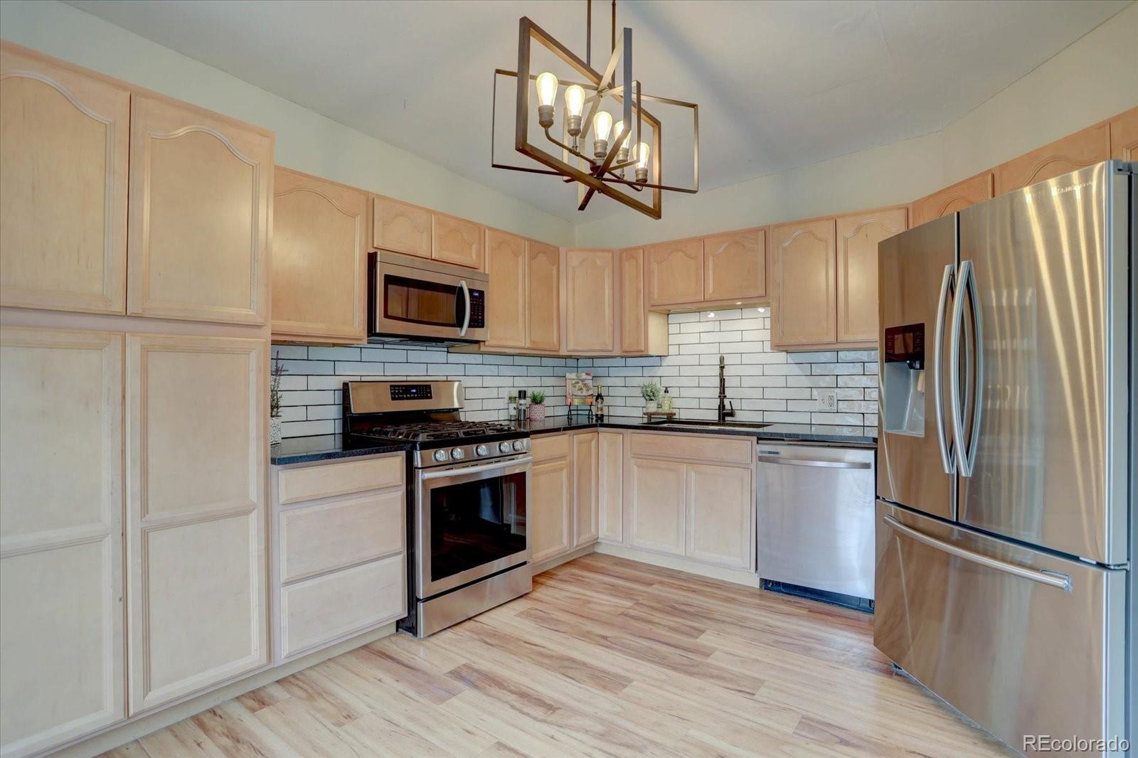 9288 Krashin Drive Conifer, CO 80433 - Photo 7 of 34 a kitchen with stainless steel appliances granite countertop a refrigerator a stove top oven a sink and dishwasher