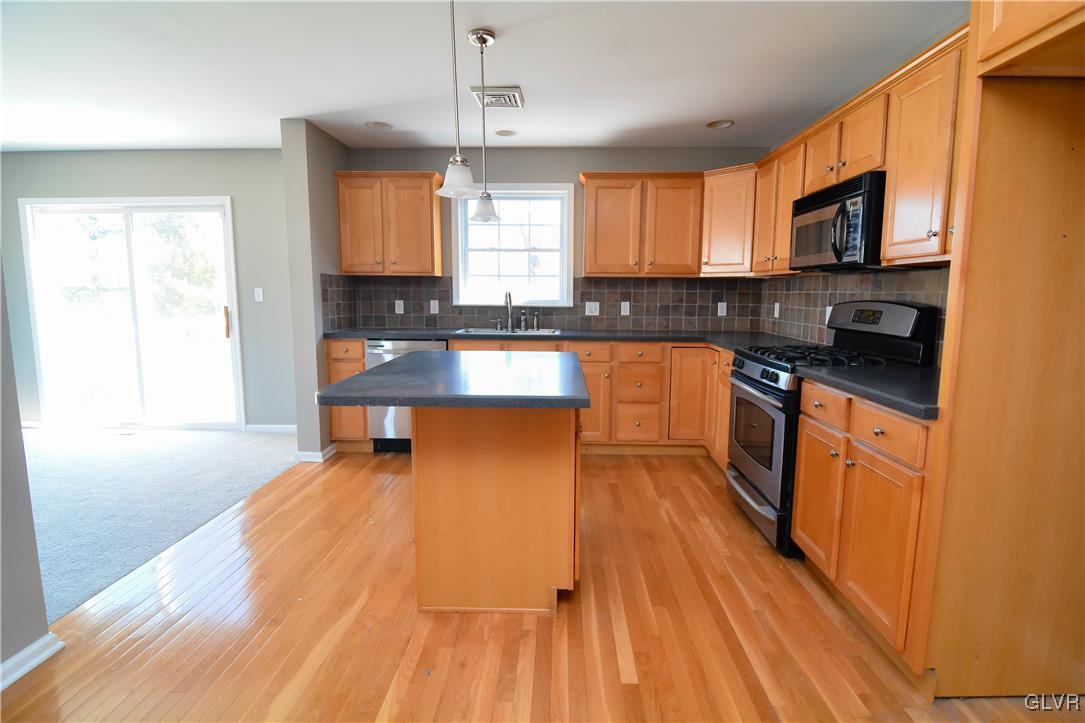 4190 Ross Road Bethlehem, PA 18020 - Photo 4 of 44 a kitchen with stainless steel appliances wooden floors wooden cabinets and sink