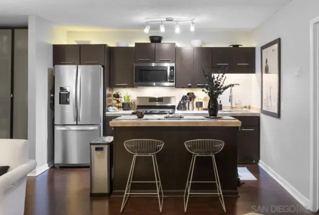 a kitchen with stainless steel appliances a refrigerator a sink and a stove