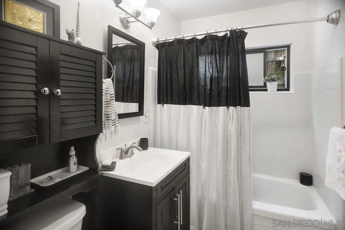 720 West Lewis Street, Unit 6 San Diego, CA 92103 - Photo 5 of 8 a bathroom with a sink a mirror and shower