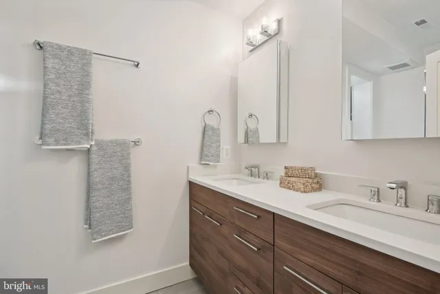 a bathroom with a granite countertop toilet a sink and shower