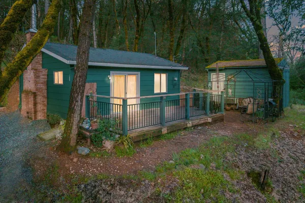 a view of a chair and table in backyard of the house