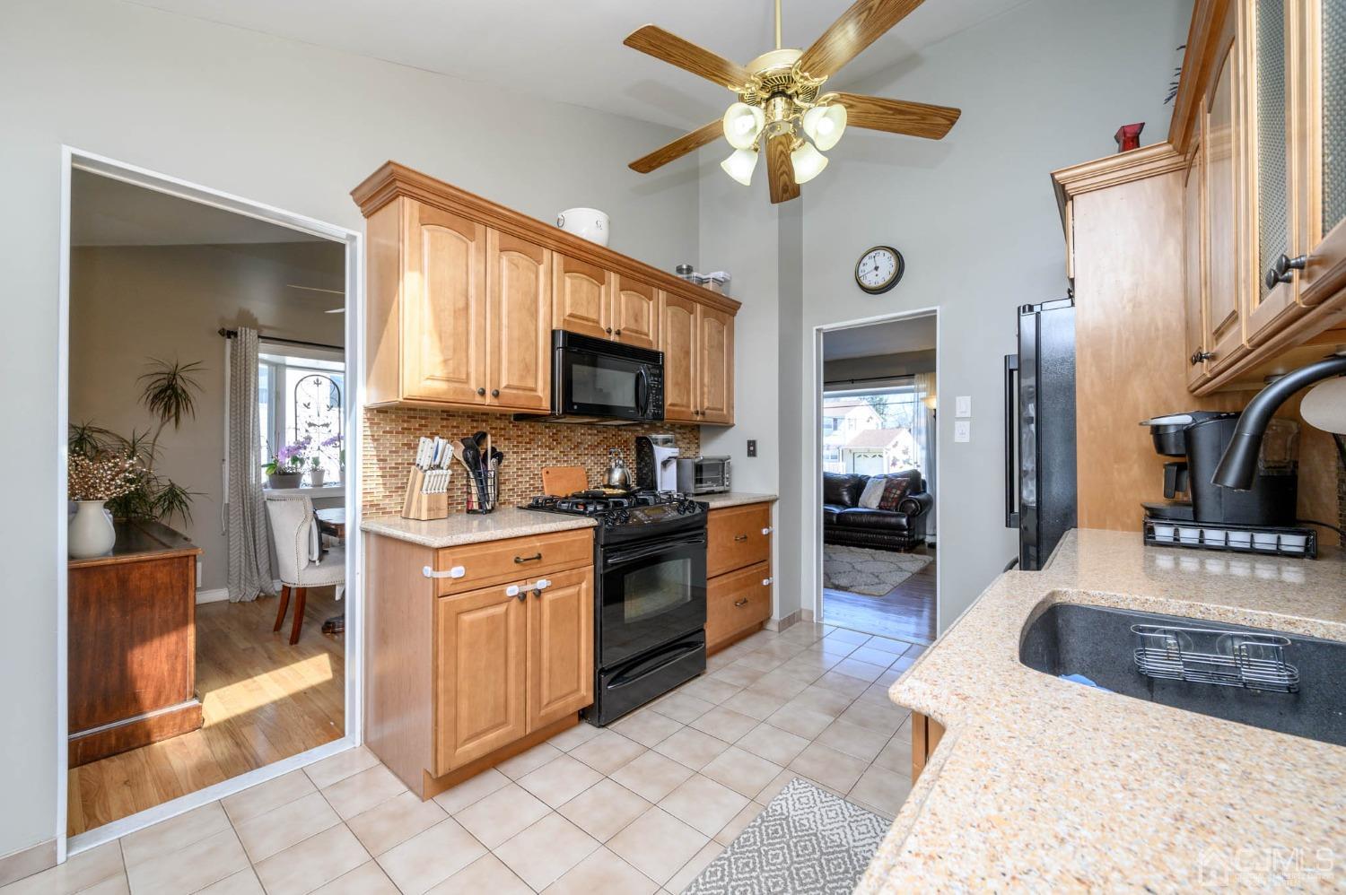 44 Owens Road Old Bridge, NJ 08857 - Photo 19 of 48 a large kitchen with stainless steel appliances granite countertop a stove top oven a sink dishwasher a dining table and chairs with wooden floor