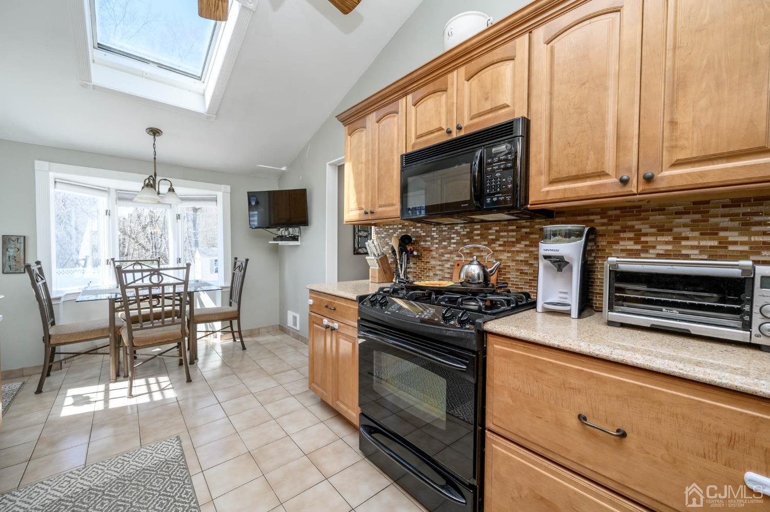 44 Owens Road Old Bridge, NJ 08857 - Photo 22 of 48 a kitchen with stainless steel appliances granite countertop a stove top oven a sink a dining table and chairs