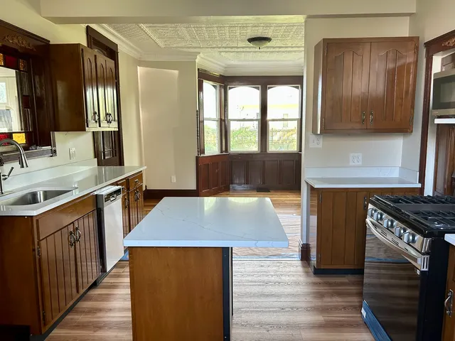 a kitchen with stainless steel appliances granite countertop a sink stove and refrigerator