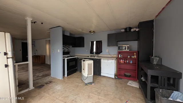 a kitchen with stainless steel appliances kitchen island granite countertop a refrigerator oven a sink and dishwasher