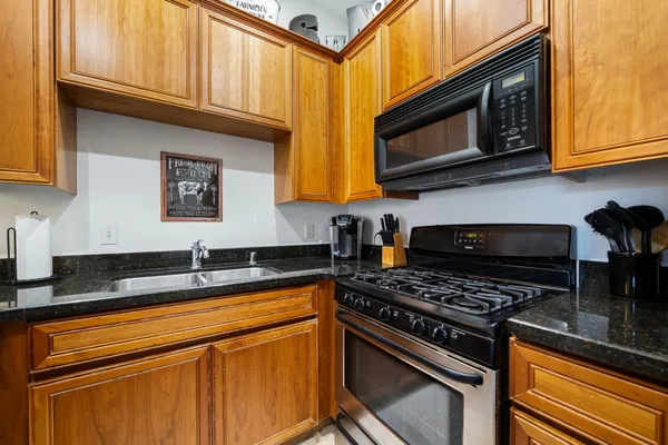 a kitchen with stainless steel appliances granite countertop a stove microwave and sink