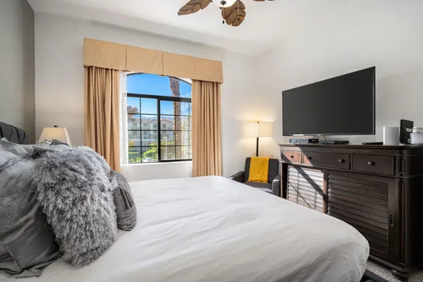 a bedroom with a bed and a flat screen tv