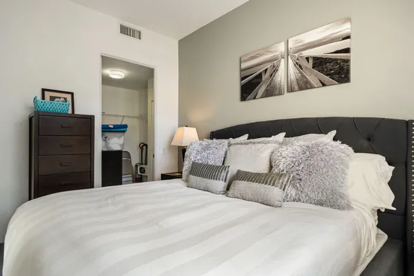 a bedroom with a bed and painting on the wall