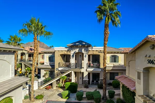 a front view of a house with a palm tree