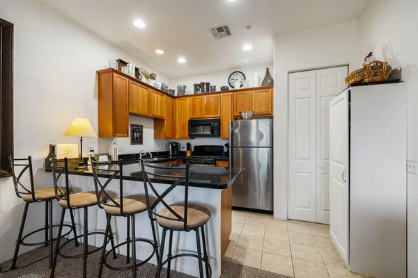 a kitchen with stainless steel appliances granite countertop a refrigerator and a stove top oven