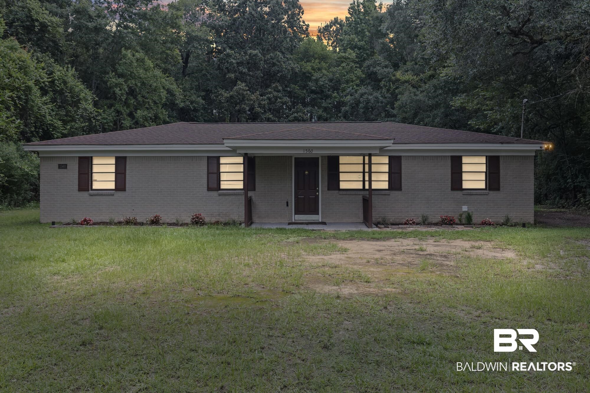 1560 Military Road Mount Vernon, AL 36560 - Photo 2 of 26 Single-story residence featuring a brick exterior with dark shutters, a dark roof, and a covered entryway