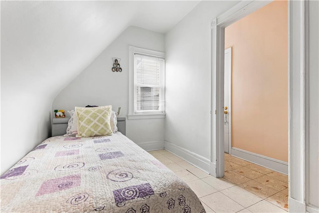 8745 17th Avenue Brooklyn, NY 11214 - Photo 25 of 31 a bedroom with a bed and a window