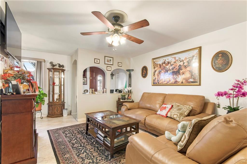 8745 17th Avenue Brooklyn, NY 11214 - Photo 4 of 31 a living room with furniture a rug and a window