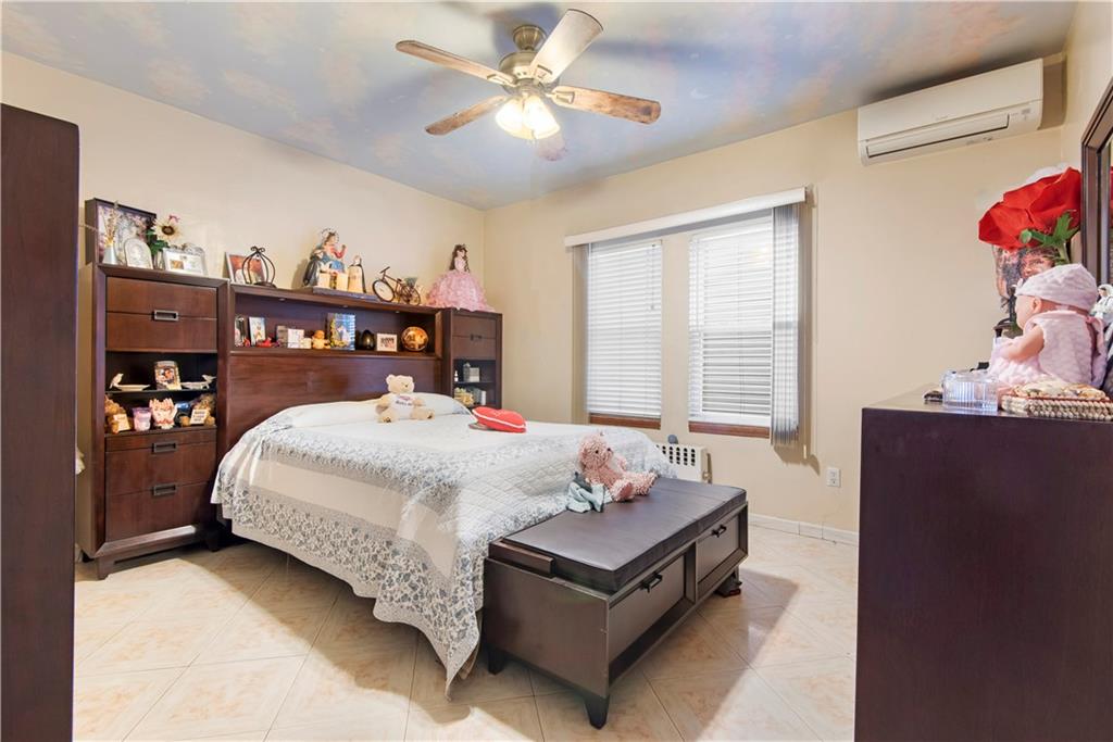 8745 17th Avenue Brooklyn, NY 11214 - Photo 10 of 31 a bed sitting in a bedroom next to a window