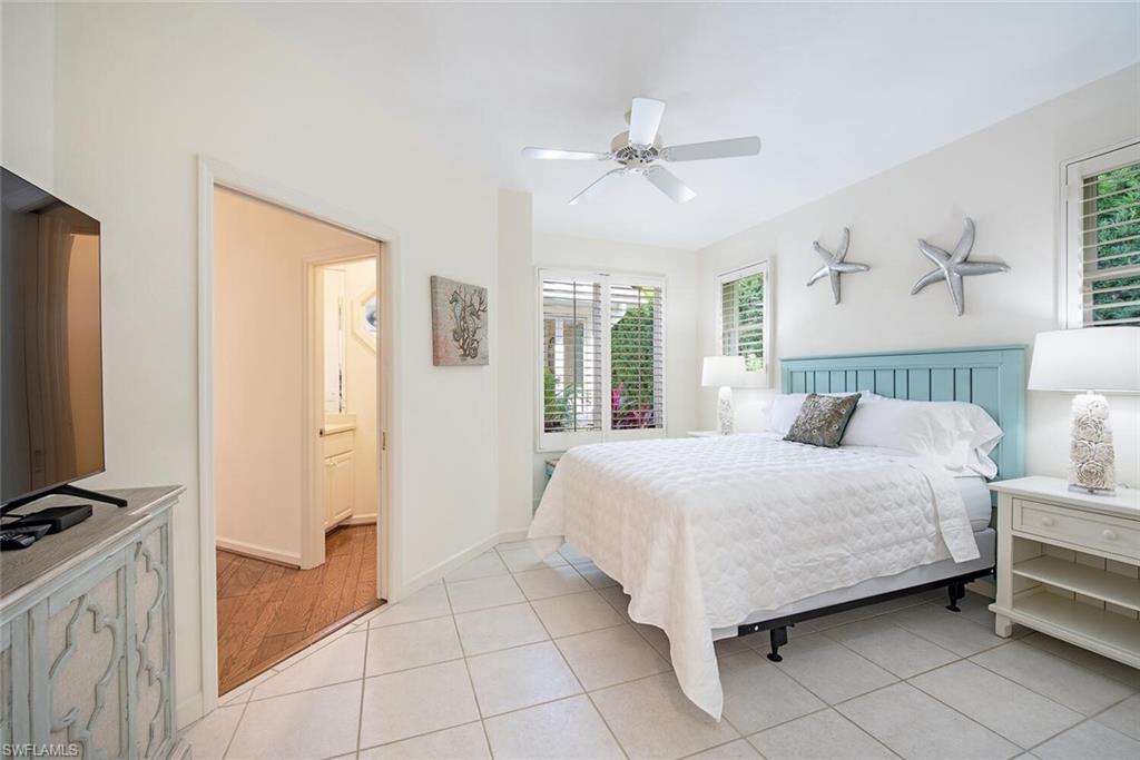 369 2nd Avenue North Naples, FL 34102 - Photo 14 of 25 a bedroom with a bed and a flat tv screen on dresser