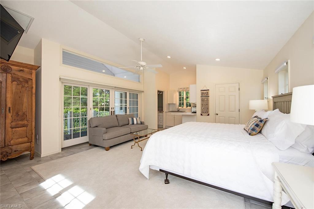 369 2nd Avenue North Naples, FL 34102 - Photo 19 of 25 a spacious bedroom with a bed a couch and large window