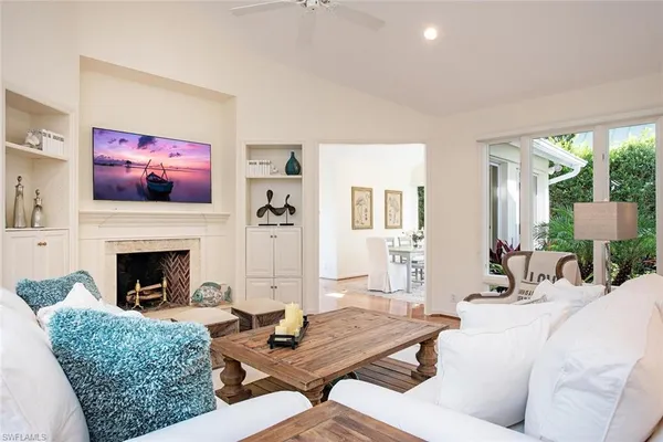a living room with furniture a fireplace and a large window