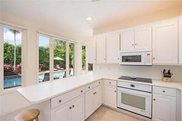 a kitchen with white cabinets white stainless steel appliances and sink