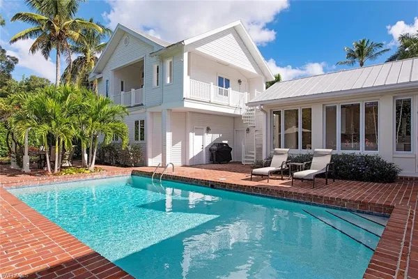 a view of a house with swimming pool and sitting area