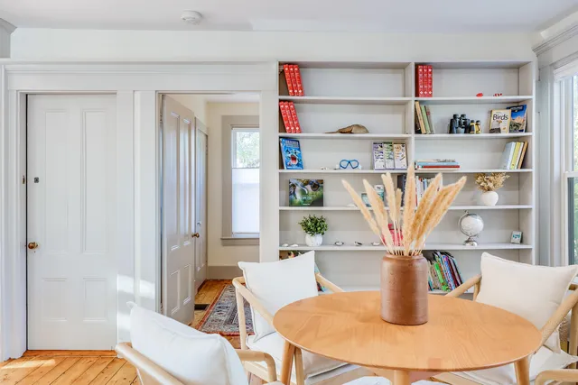 a view of a dining room with furniture and a book shelf