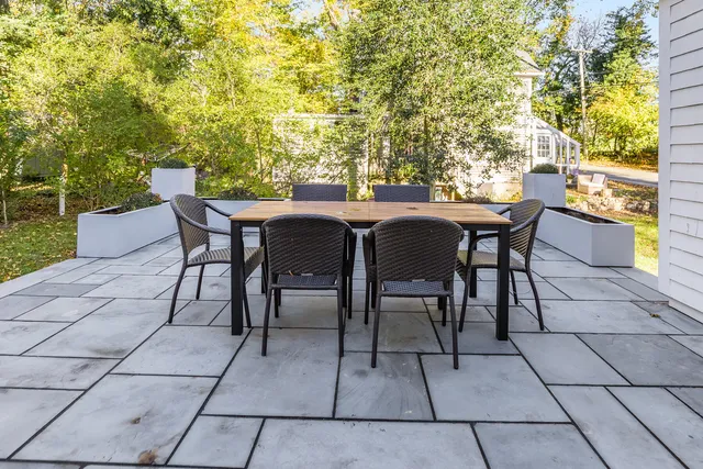 a view of a patio with table and chairs and potted plants