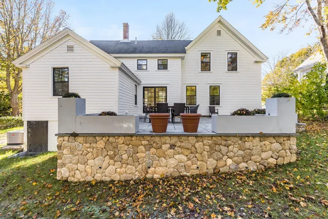 a view of a house with backyard and sitting area