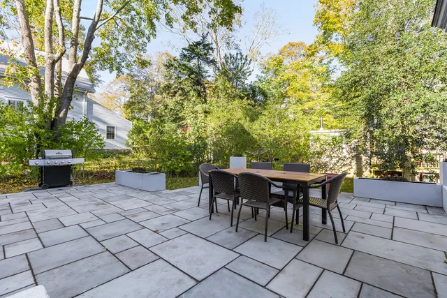 a view of a patio with a table and chairs and potted plants