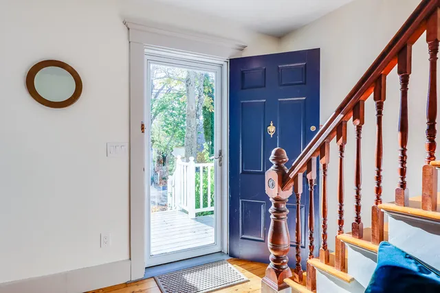 a view of an entryway with wooden floor and front door