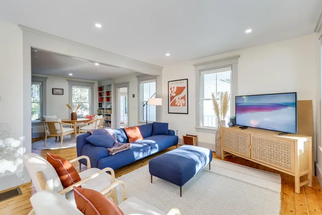 a living room with furniture a flat screen tv and paintings on the wall