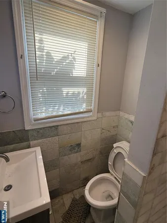 a bathroom with a sink a toilet and a window
