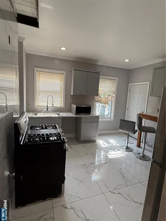 a kitchen with granite countertop a stove a sink and a refrigerator