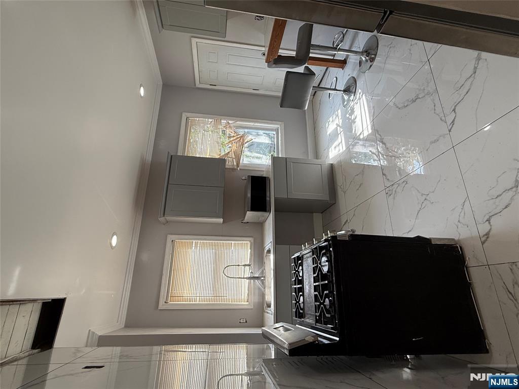 753 South 11th Street, Unit 1 Newark, NJ 07103 - Photo 8 of 17 a kitchen with granite countertop a stove a sink and a refrigerator