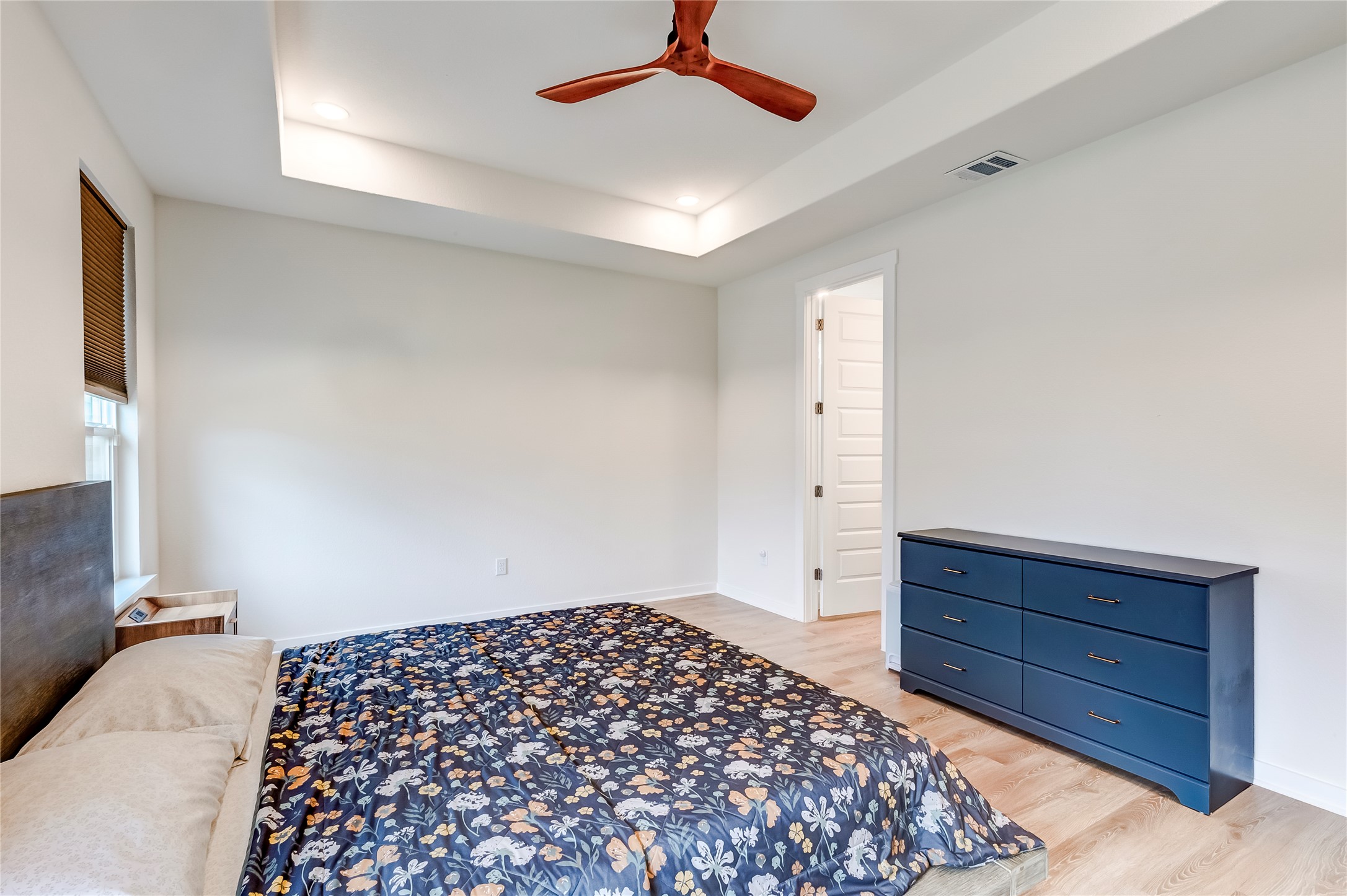 917 Balsora Cove Georgetown, TX 78628 - Photo 19 of 39 Bedroom featuring light wood-style flooring, a raised ceiling, a ceiling fan, and recessed lighting
