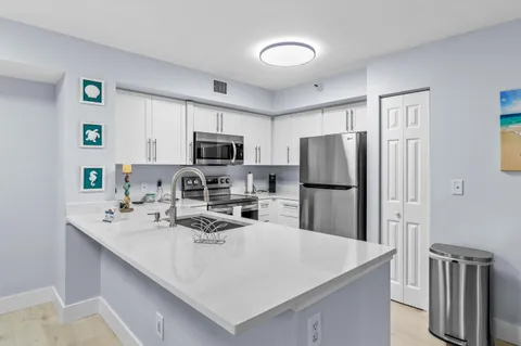 a kitchen with stainless steel appliances a refrigerator sink stove microwave and cabinets