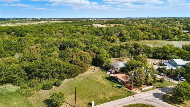 an aerial view of residential houses with outdoor space and lake view