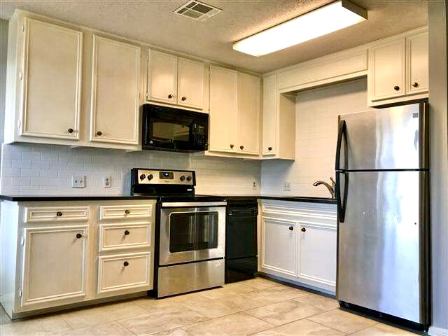 502 West 17th Street, Unit B Austin, TX 78701 - Photo 2 of 3 a kitchen with stainless steel appliances granite countertop a refrigerator stove and sink