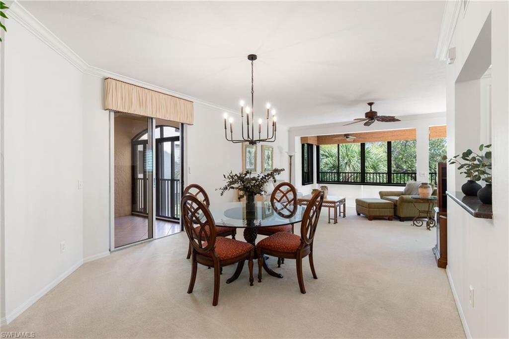 6500 Valen Way, Unit A203 Naples, FL 34108 - Photo 12 of 28 a view of a dining room with furniture a chandelier and large windows