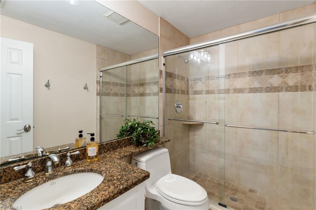 6500 Valen Way, Unit A203 Naples, FL 34108 - Photo 15 of 28 a bathroom with a granite countertop sink toilet and shower