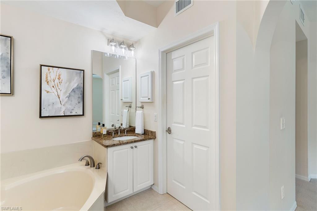 6500 Valen Way, Unit A203 Naples, FL 34108 - Photo 22 of 28 a bathroom with a bathtub and a shower