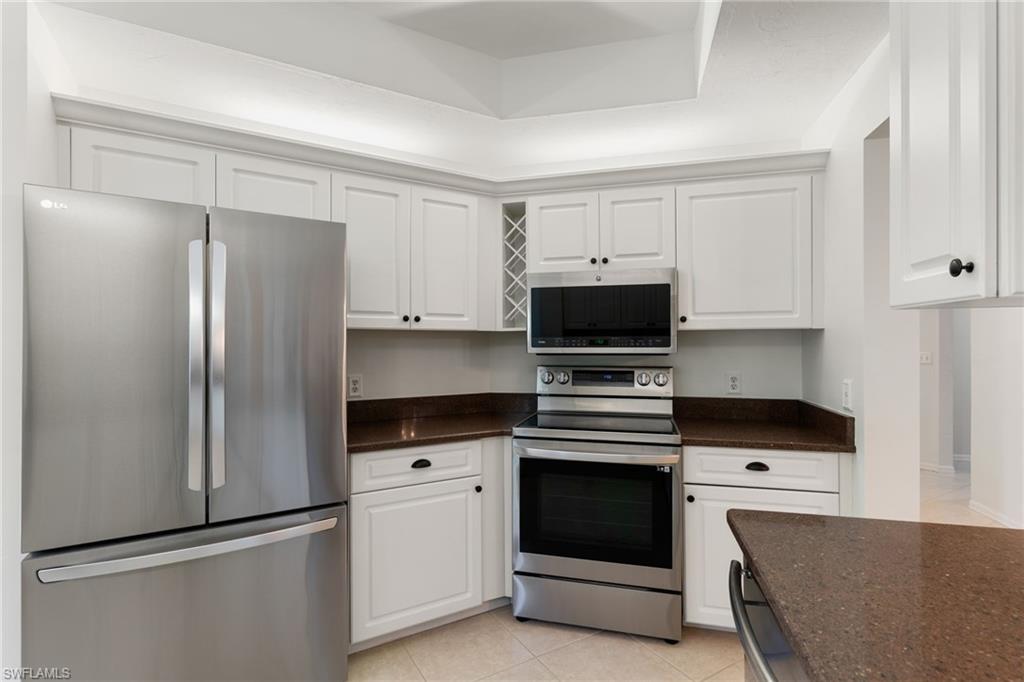 6500 Valen Way, Unit A203 Naples, FL 34108 - Photo 4 of 28 a kitchen with stainless steel appliances a refrigerator sink and cabinets