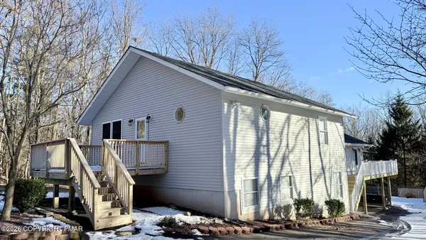 a view of backyard with large trees and wooden fence