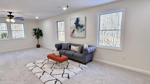 a living room with furniture a window and a potted plant